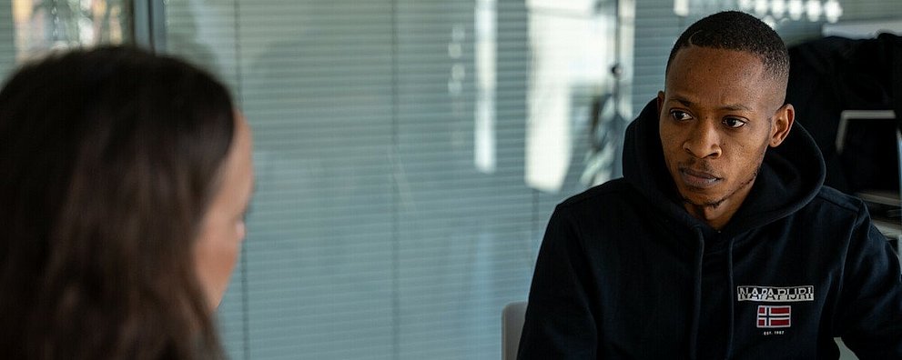 Gesprächssituation: Frau berät Geflüchteten