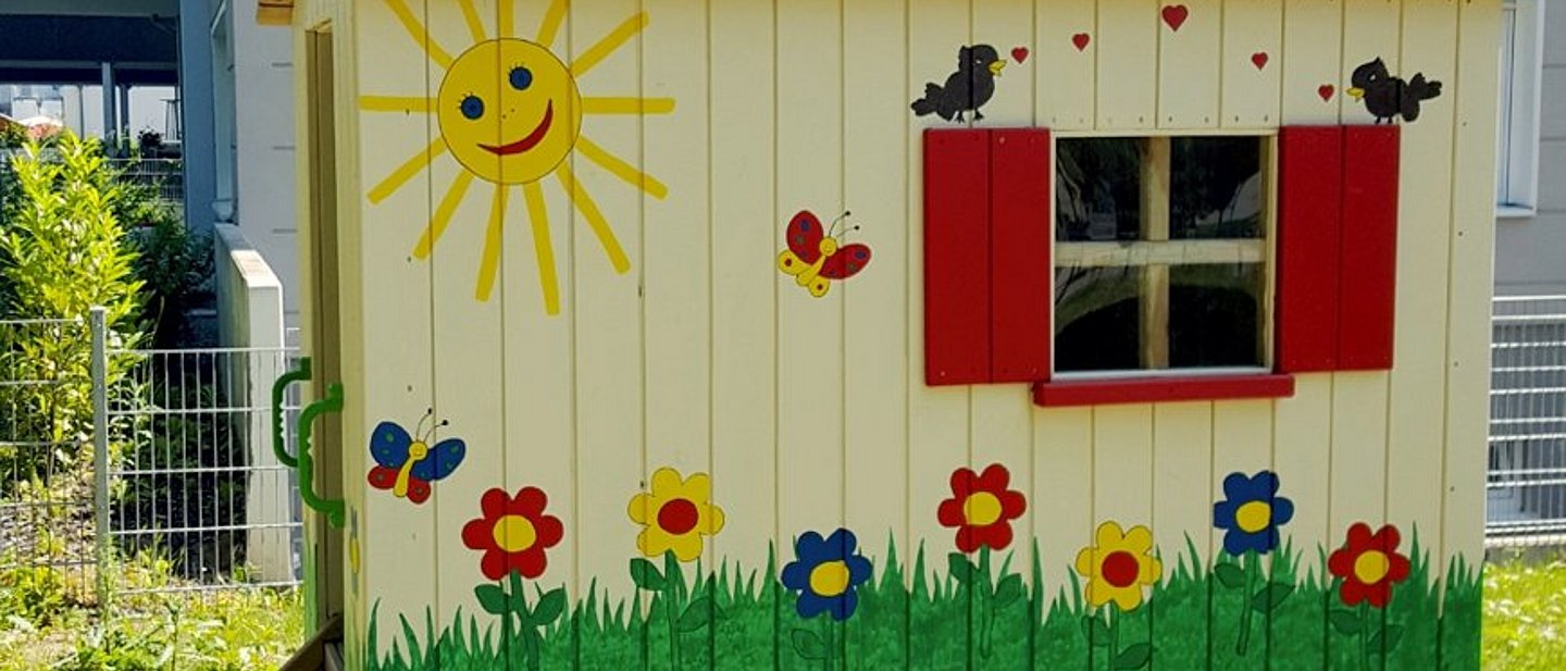Buntbemalter Bauwagen im Hof einer evangelischen Kita