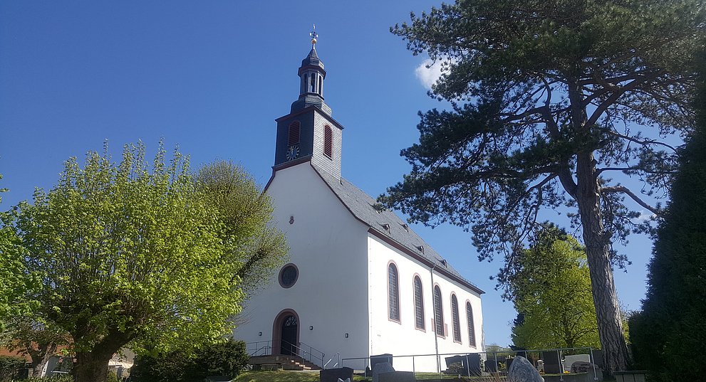 Außenansicht der Evangelischen Kirche in Ober-Ramstadt von der Westseite mit Eingangstür im Frühling