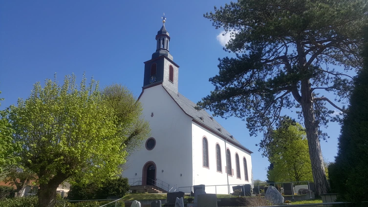 Außenansicht der Evangelischen Kirche in Ober-Ramstadt von der Westseite mit Eingangstür im Frühling