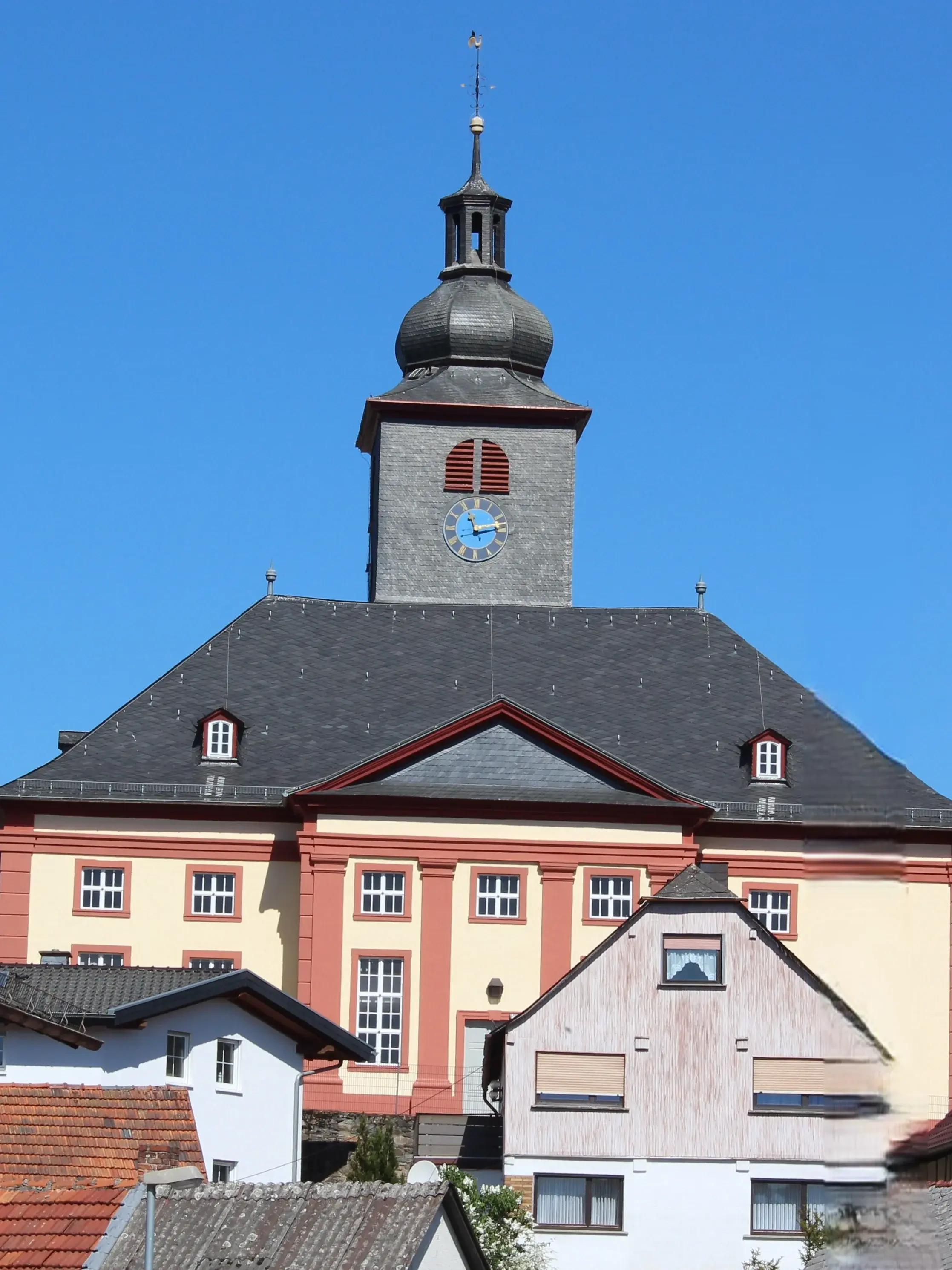 Evangelische Kirche in Grävenwiesbach von der Straßenseite mit Bäumen