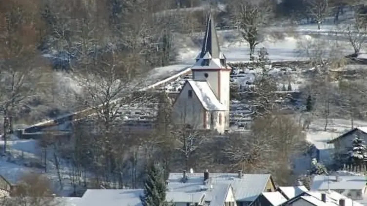 Blick auf winterlich-verschneite Bergkirche und Friedhof von Westen