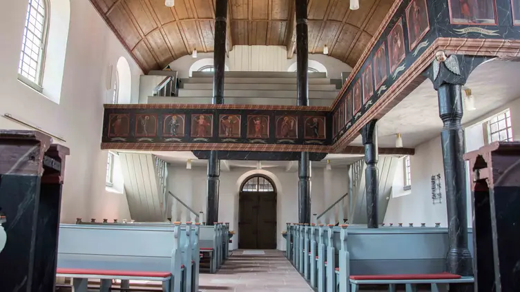 Blick in den Innenraum der evangelischen Kirche Burgholzhausen vom Altar den Mittelgang entlang.