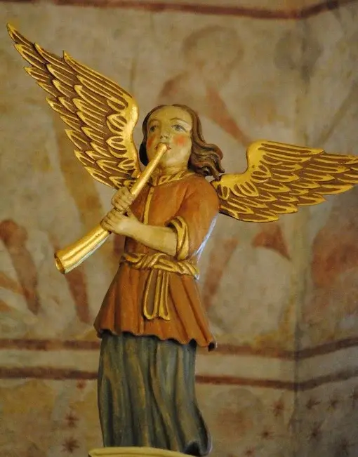 Engel mit Flöte auf Kirchenorgel; Fresken im Hintergrund