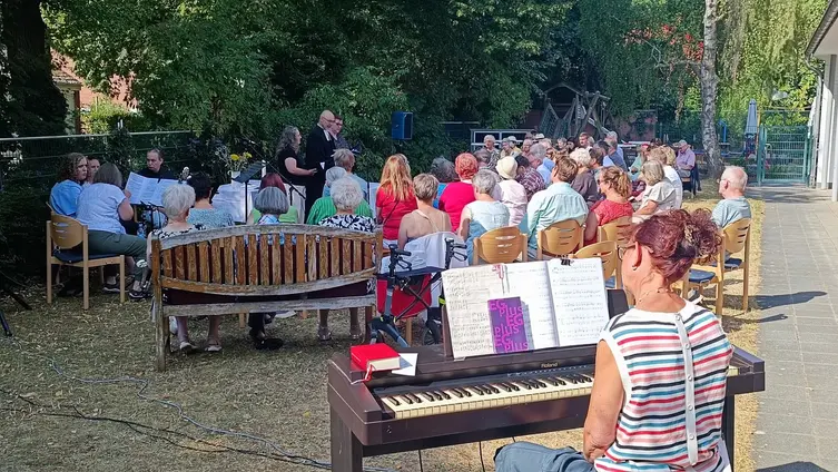 Personen bei einem Gottesdienste uf der Wiese vor der evangelischen Kirche in Worms-Herrnsheim