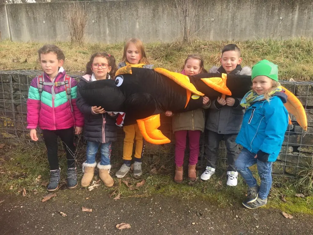 Das Foto zeigt Kinder der KiTa "Haus des Kindes" mit ihrem riesigen Kuscheltierfisch.