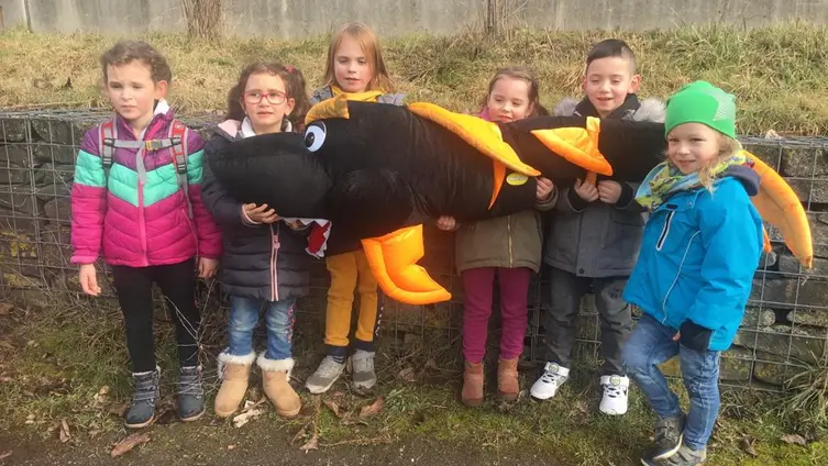 Das Foto zeigt Kinder der KiTa "Haus des Kindes" mit ihrem riesigen Kuscheltierfisch.