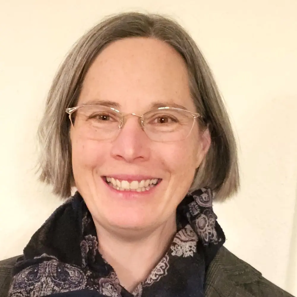 Frau mit Brille und mittelblonden, halblangen Haaren