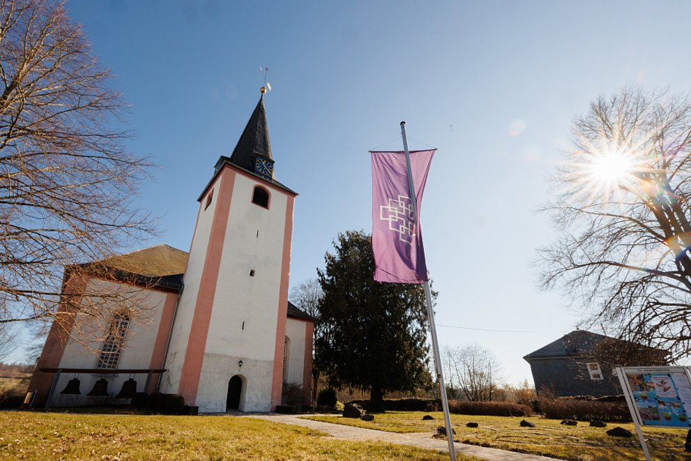 Ev. Kirche Neunkirchen im Westerwald im Sonnenschein mit EKHN-Fahne