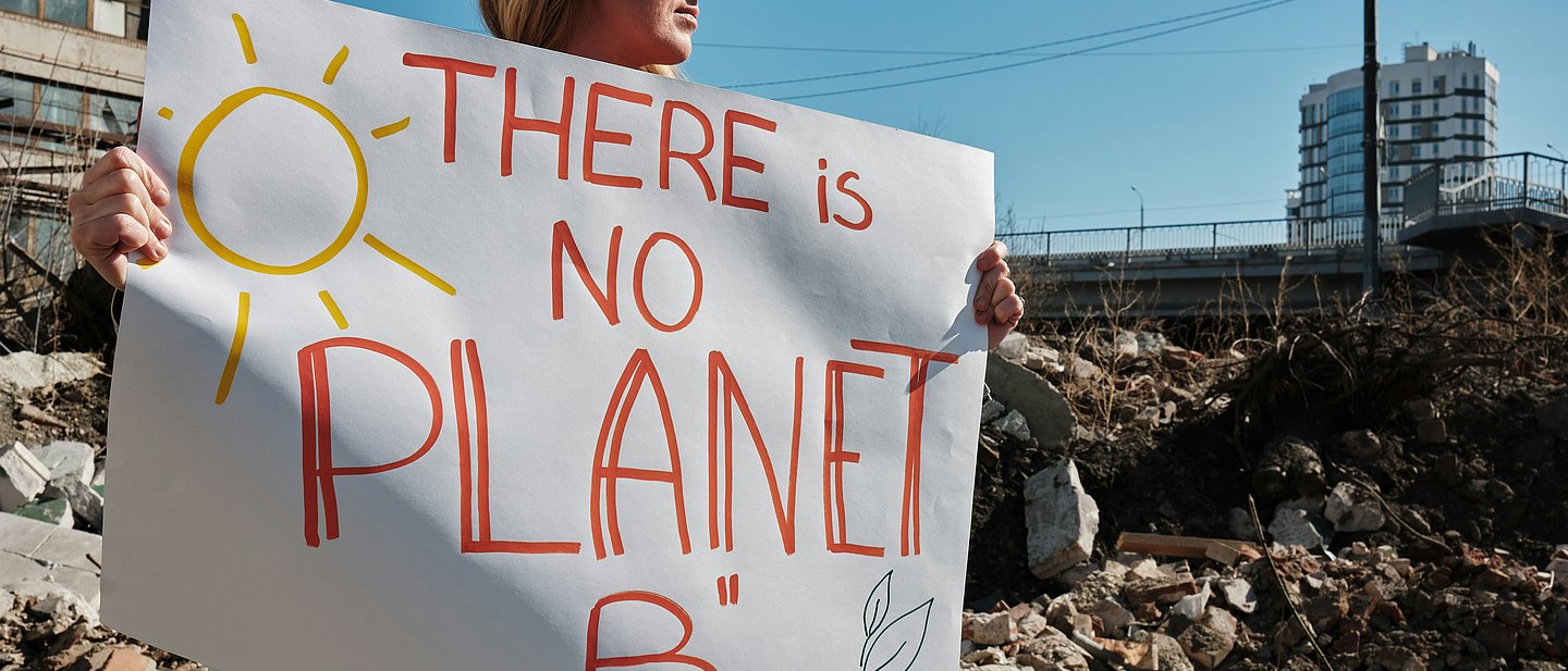 Frau hält Plakat: There is no planet B