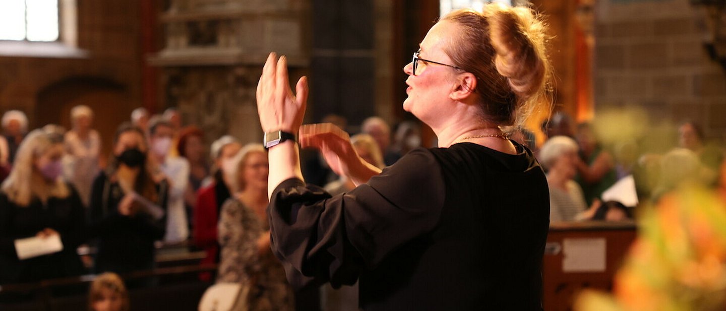 Frauen und Männer singen und stehen, in einer Kirche, zusammen.