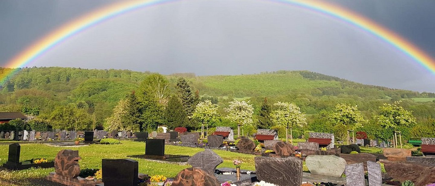 Ein Regenbogen der sich über dem Friedhof von Gemünden erhebt.
