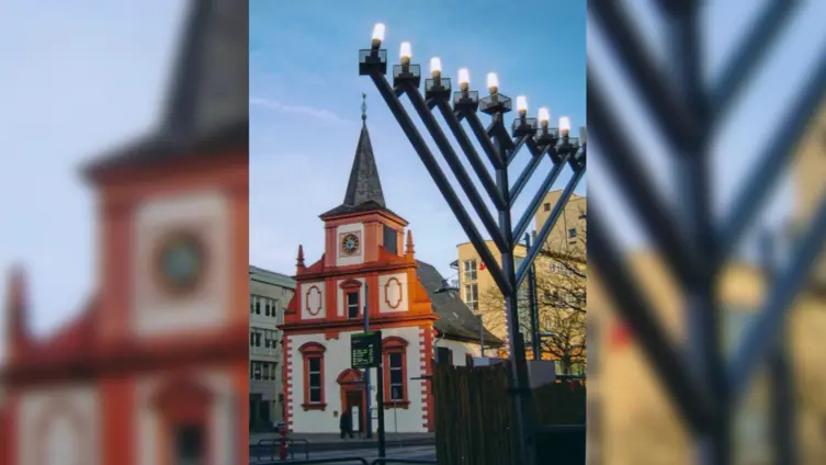 Chanukka-Flamme am Rathaus mit Blick auf die Kirche