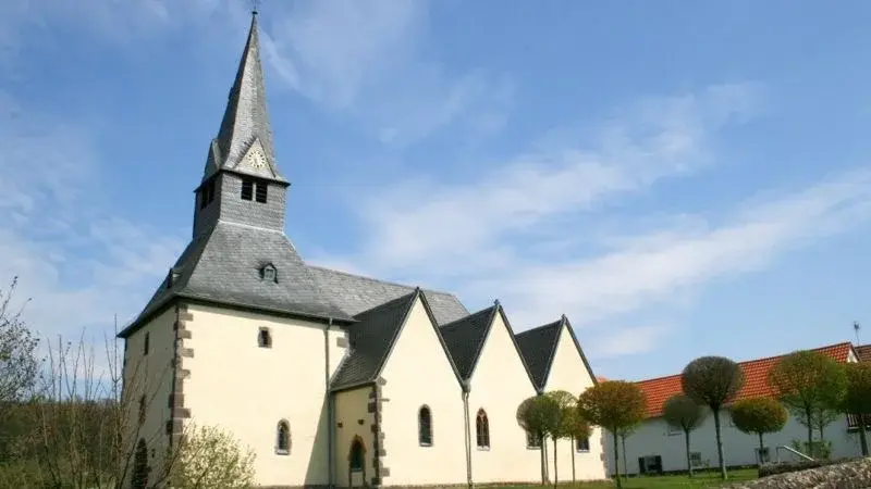 750 Jahre alte Kirche im Sonnenschein mit Garten davor