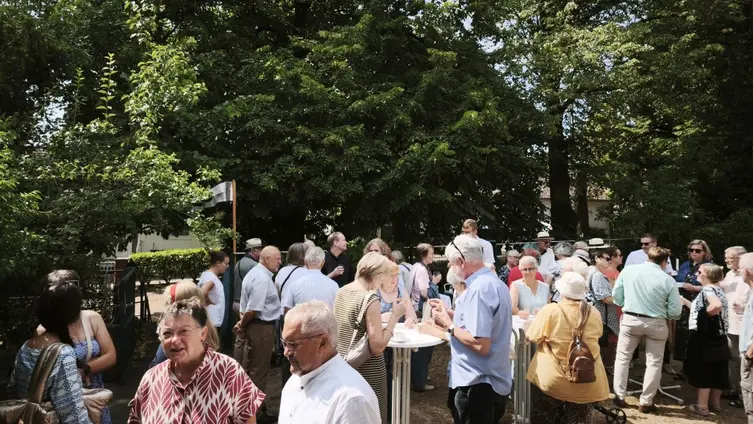 Personen bei einem Gottesdienste uf der Wiese vor der evangelischen Kirche in Worms-Herrnsheim