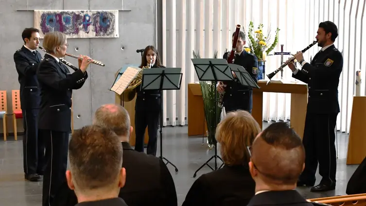 5 Musiker und Musikerinnen in Uniformen musizieren in der Kirche