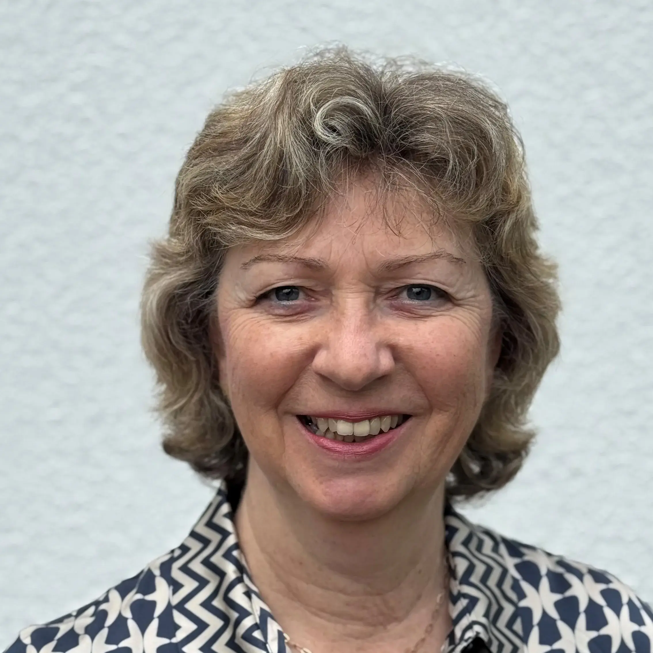 Portrait von Margit Bonnet vor einer weißen Wand