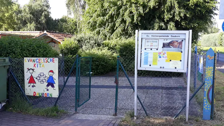 Schaukasten und Tor vom Parkplatz an der Kita Dauborn