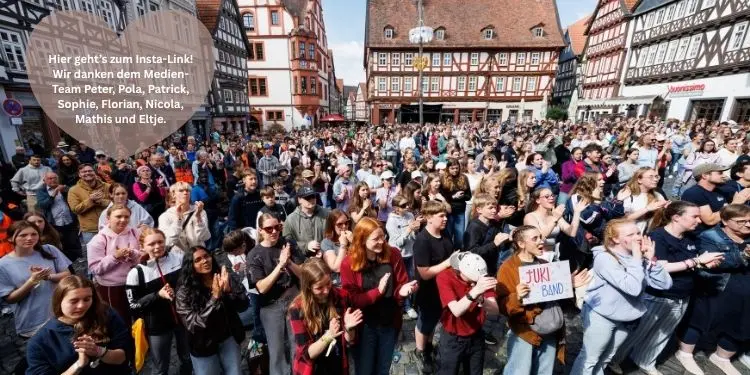 Viele Jugendliche auf einem großen Platz, umrundet von Fachwerkhäusern