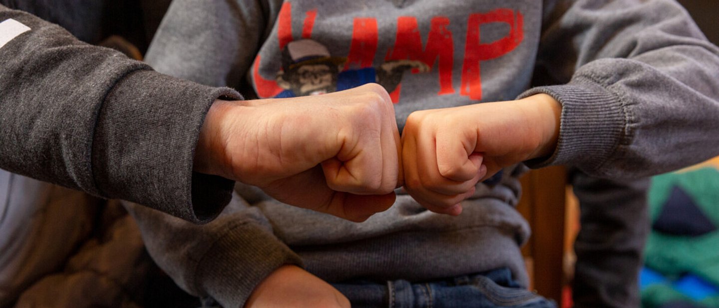 Ein Junge und ein Erwachsener drücken ihre Fäuste aneinander