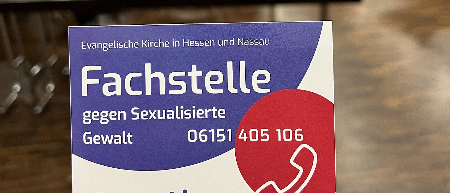 Im Vordergrund ein Faltblatt zum Thema Prävention, verschwommener Hintergrund eines Schulungsraumes