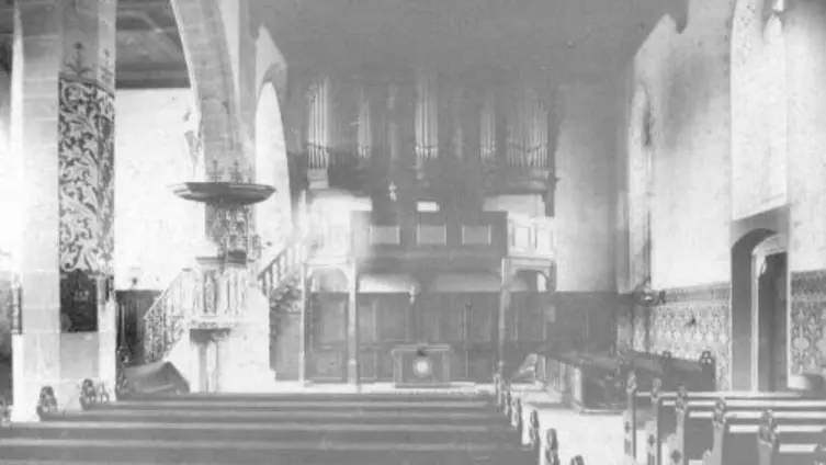 Blick in den Altarraum mit Vertäfelung, Orgelempore und Orgel