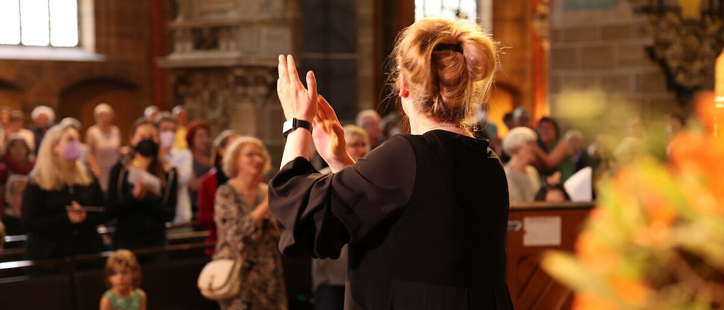 Frauen und Männer singen und stehen, in einer Kirche, zusammen.