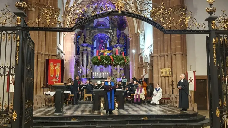 Blick in den Altarraum mit Orchester und Pfarrerin und Pfarrer