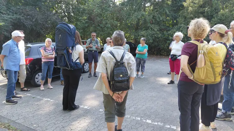 Das Foto zeigte ca. 20 Menschen in einem Kreis stehend zu Beginn der Wanderung auf dem neu beschilderten Lichterkirchenweg.
