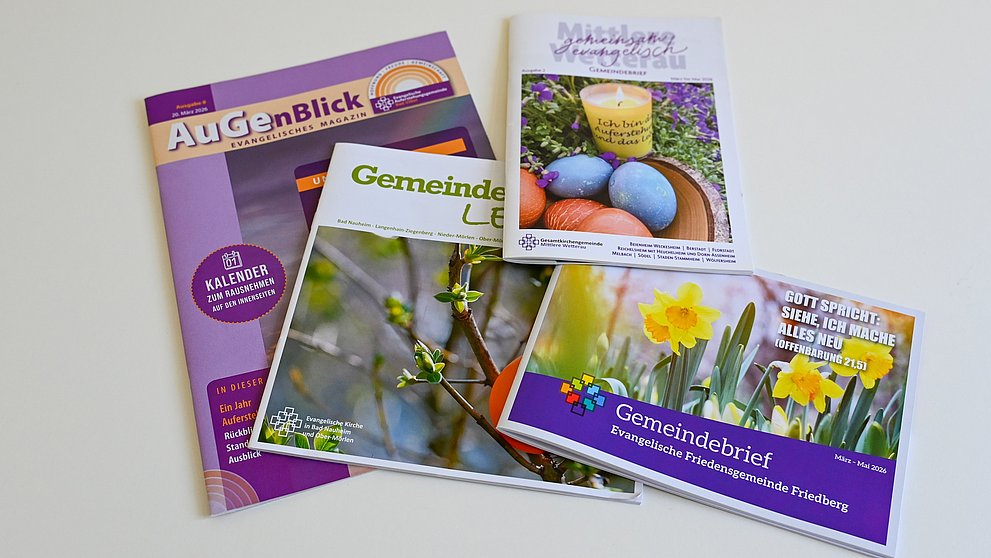 Mehrer Gemeindebriefe liegen auf einem Tisch.