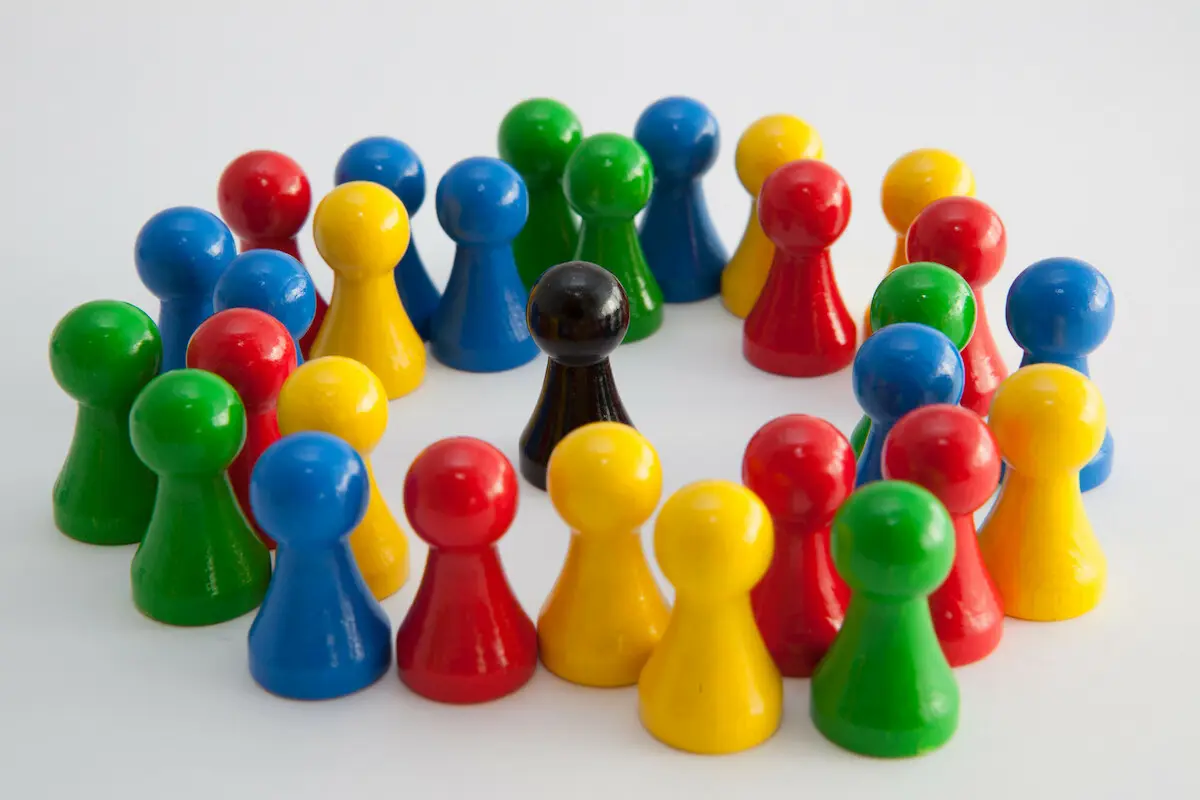 Bunte Spielfiguren umstellen eine schwarze Spielfigur