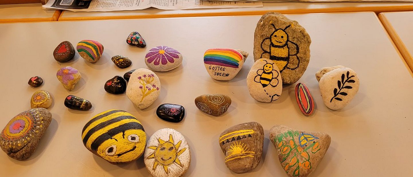 Vom Frauenkreis bemalte Steine auf einem Tisch