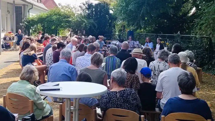 Personen bei einem Gottesdienste uf der Wiese vor der evangelischen Kirche in Worms-Herrnsheim