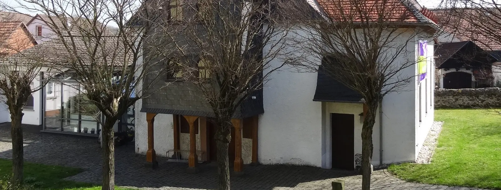 Kleine Kirche auf grünem Rasen mit Bäumen