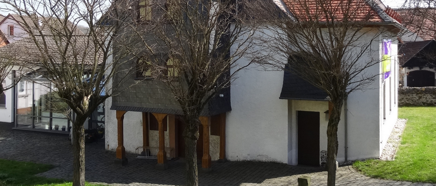 Kleine Kirche auf grünem Rasen mit Bäumen