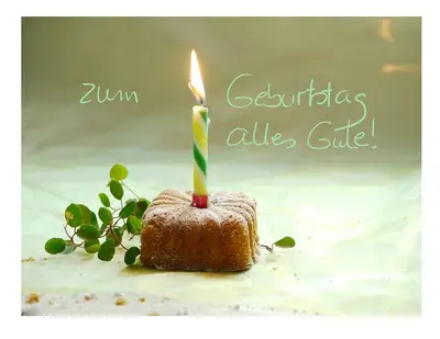 Geburtstagsgruß mit Kerze in einem Kuchen und einem Glückwunschtext