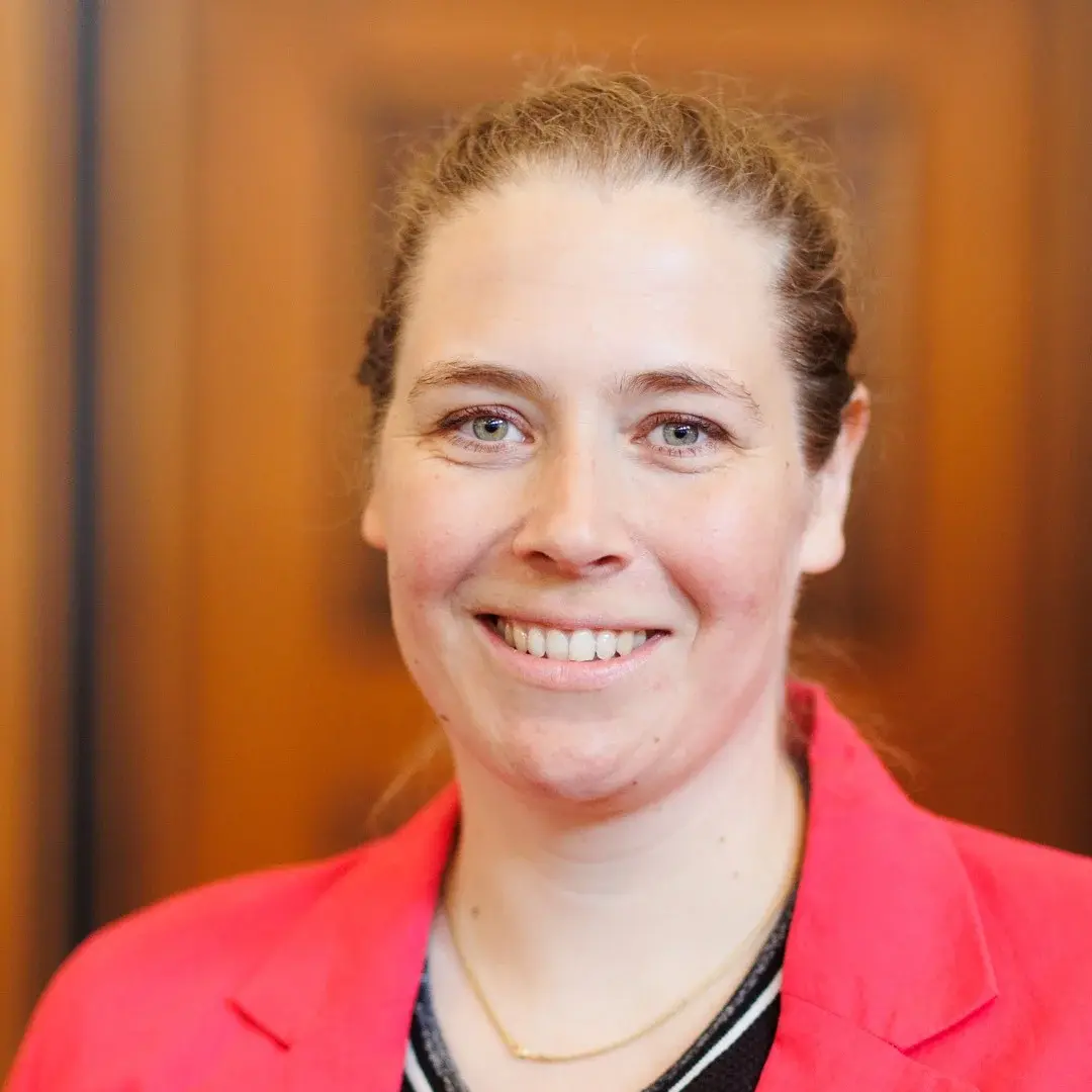 Das Bild zeigt ein Portrait von Dekanin Juliane Schüz in einem roten Blazer