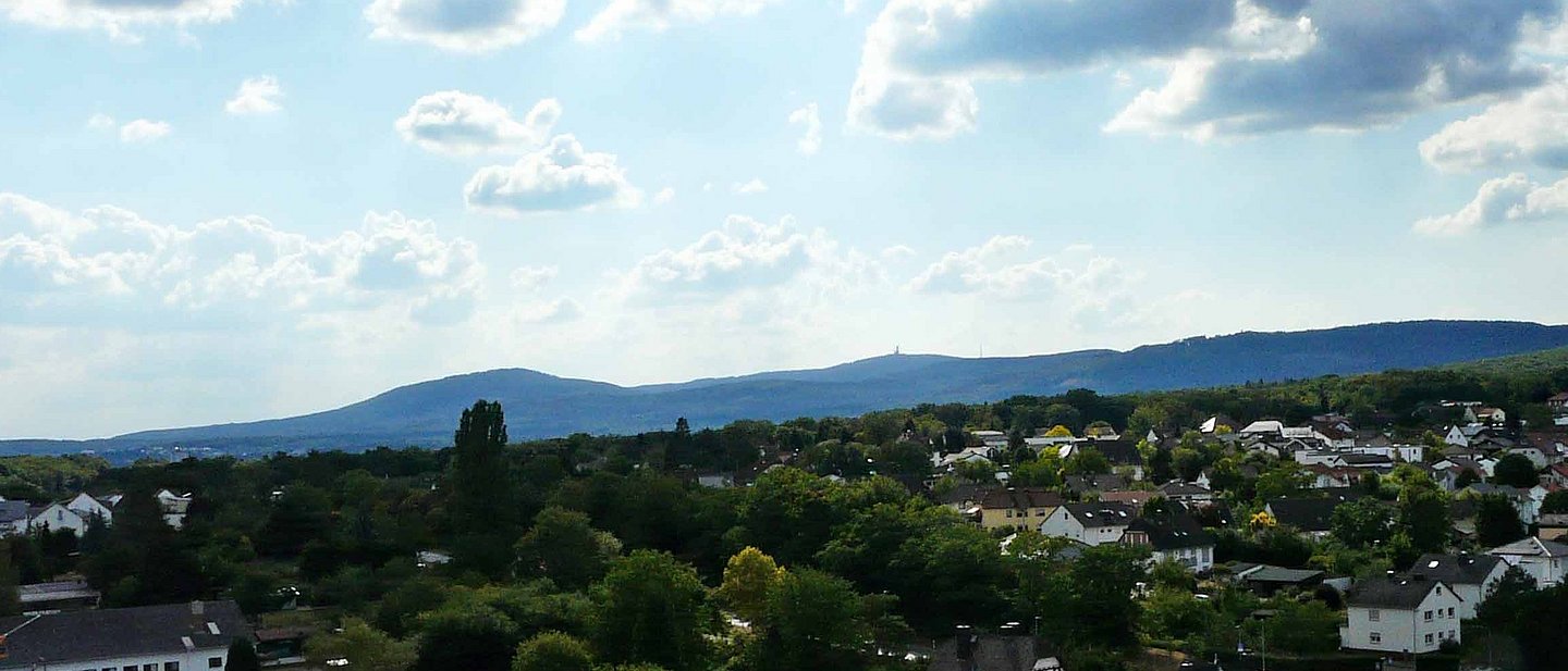 Blick auf Friedrichsdorf mit dem Taunus im Hintergrund vom Dach eines Hochhauses aus.