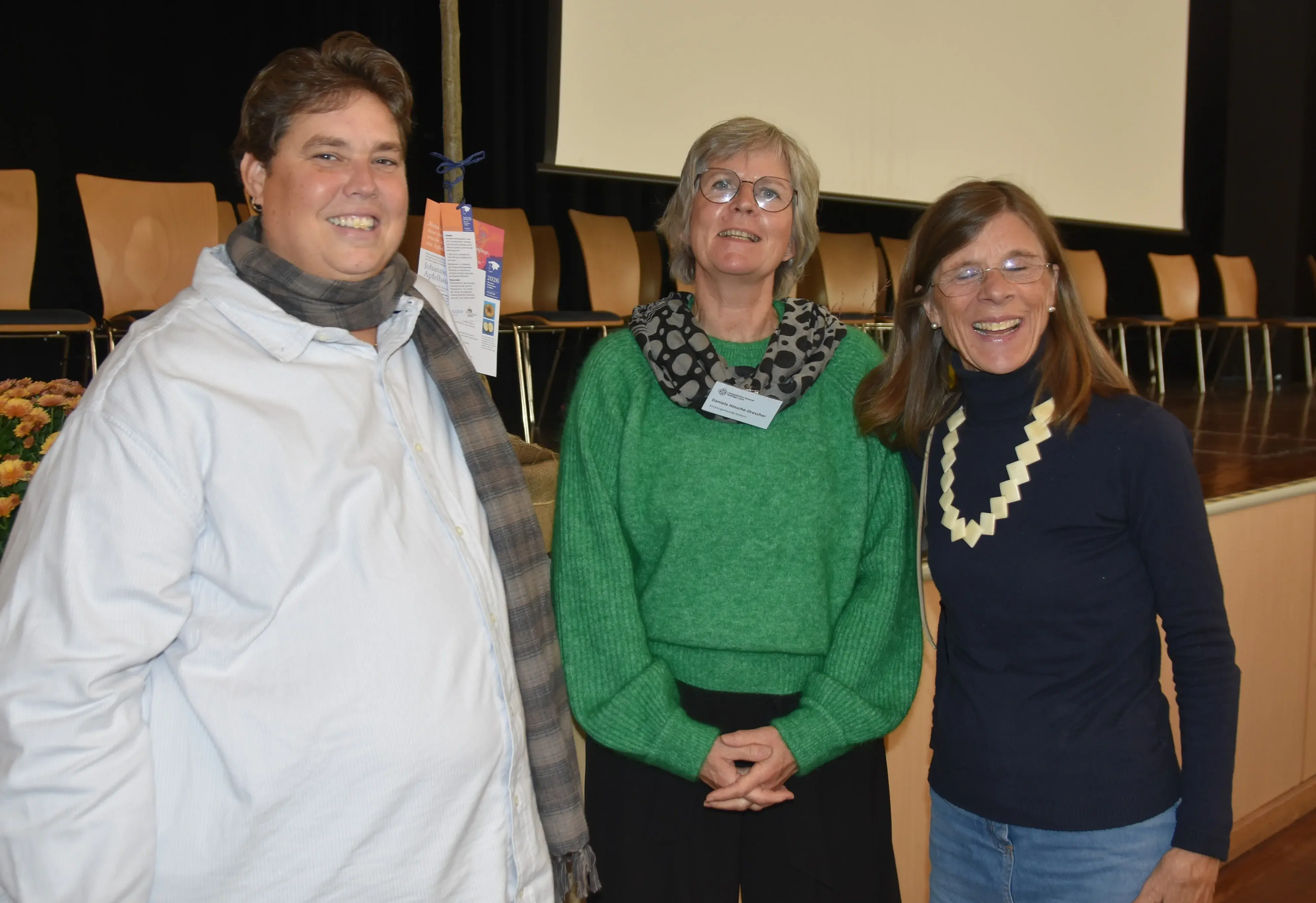 Tanja Langer, Daniela Hinsche-Drescher und Sabine Steinmeier stehen vor der Bühne im Bürgerhaus Nidda.