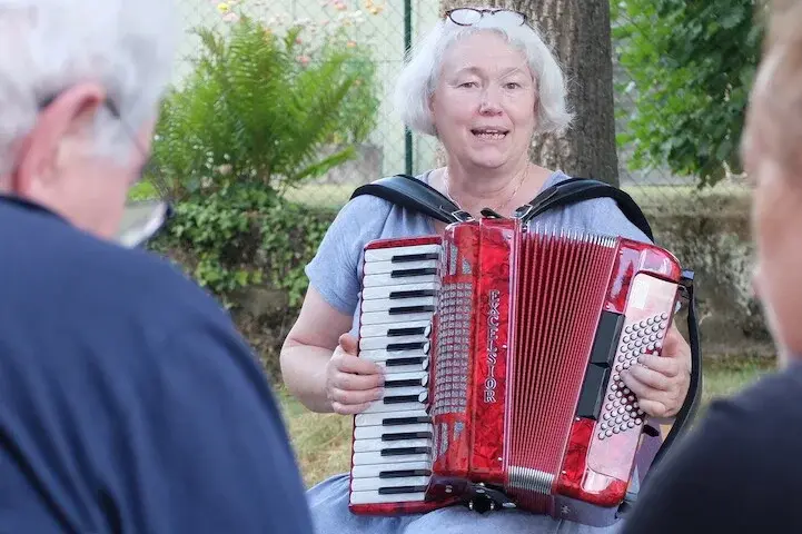 Dorothee Ewald spielt Akkordeon die Besucher*innen des Treffs.
