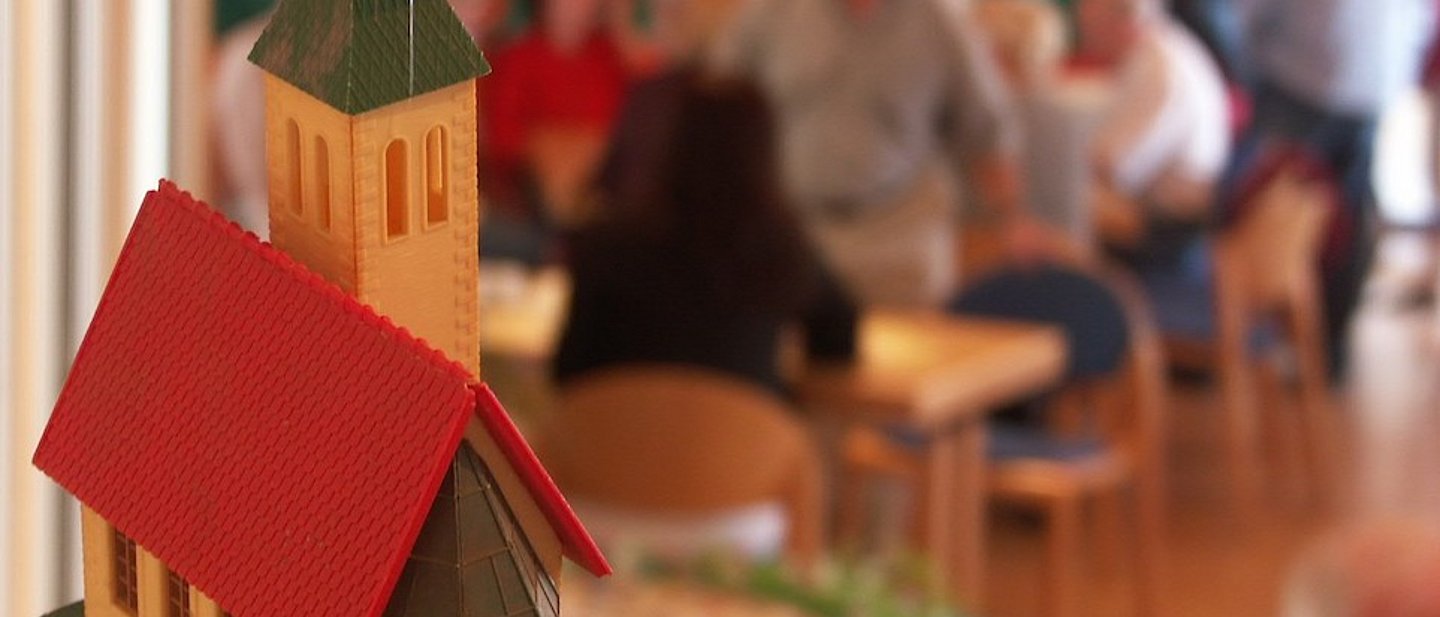 Modell einer Kirche mit Menschen im Hintergrund