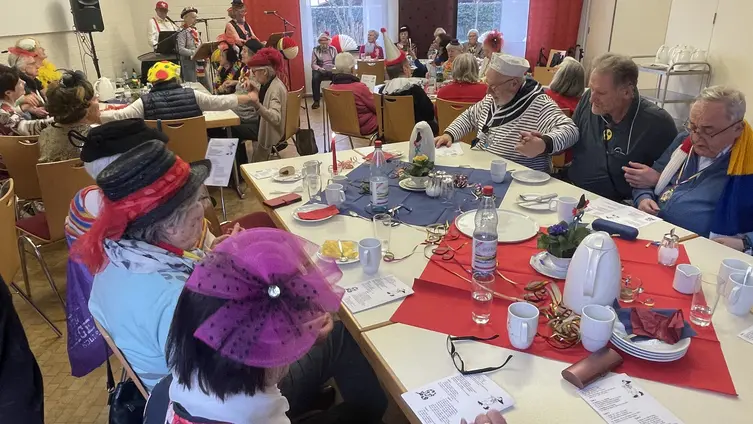 Fastnachtlich gekleidet schunkeln Senioren und Pfarrer Zirmer beim närrischen Seniorennachmittag im katholischen Pfarrheim Ginsheim 