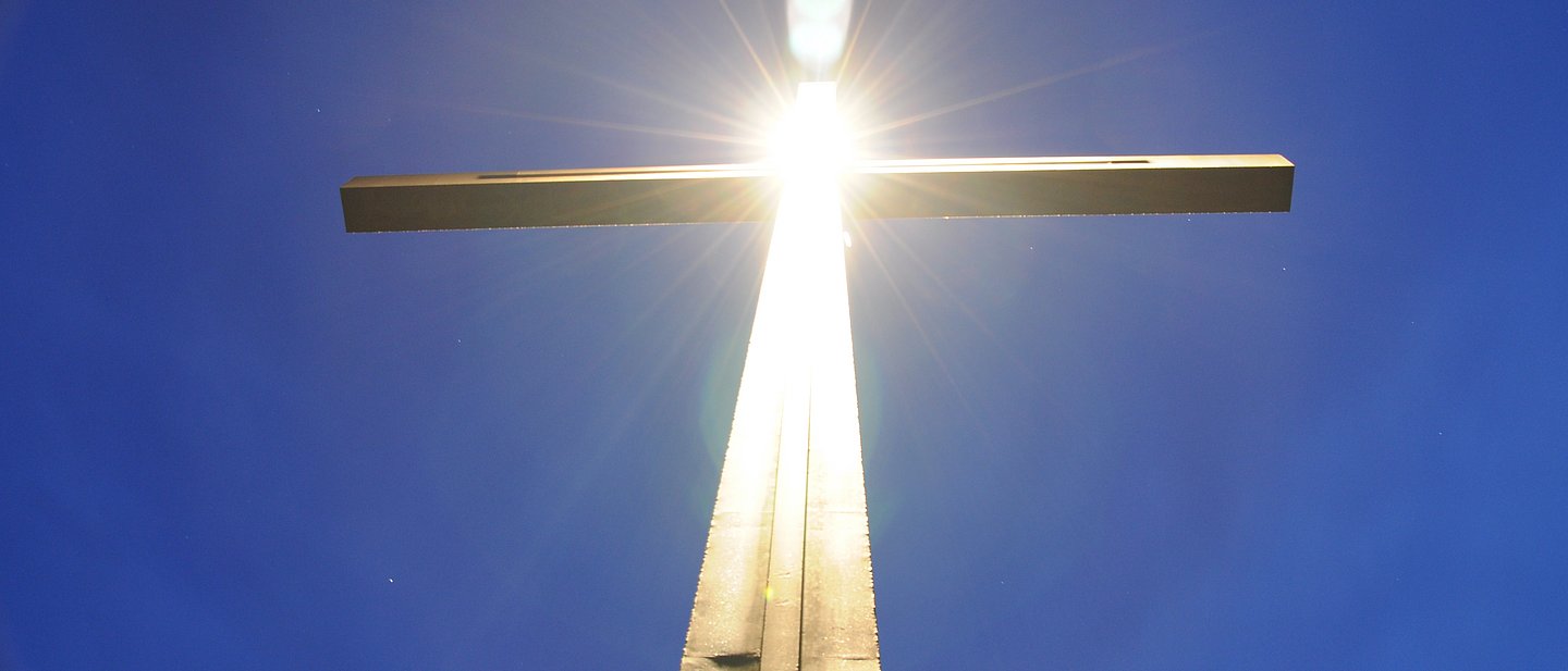 Kreuz, in dem sich die Sonne widerspiegelt