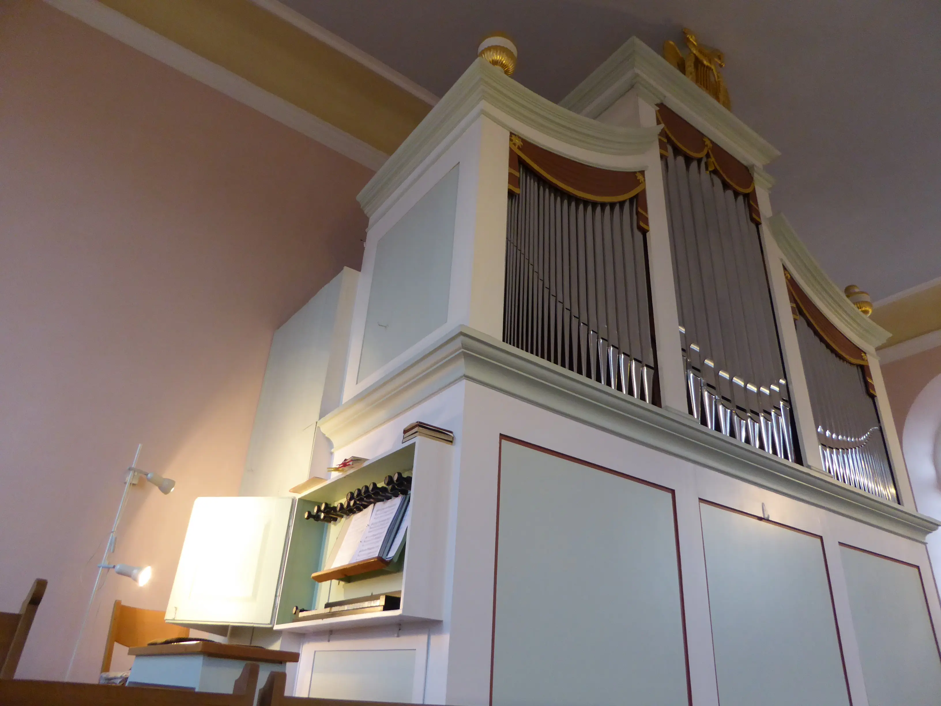 Orgel mit Manual, Sitzbank und Orgelpfeifen