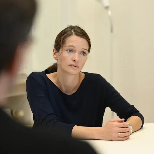 Eine Frau und ein Mann sitzen zusammen am Tisch und unterhalten sich.