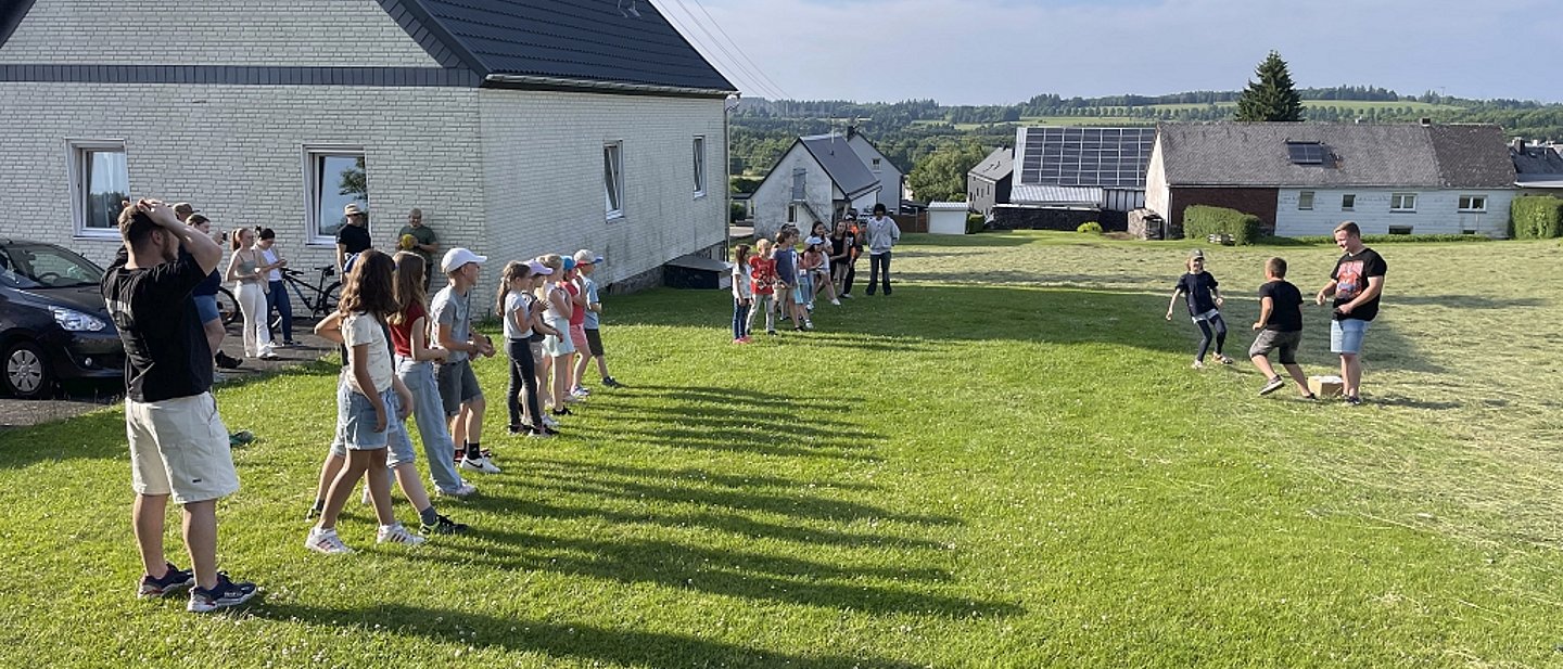 Jungenjungschar in Stein beim Spielen auf einer Wiese im Sonnenschein