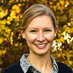 Pfarrerin Annika Marte vor einem herbstlich gefärbten Blätterwerk