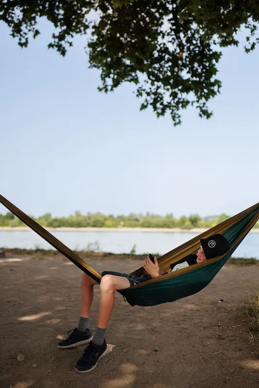 Chillen in der Hängematte beim Jugendkirchentag 2022 Man sieht einen Jugendlichen, der in einer Hängematte baumelt. Er trägt einen Hut mit JUKT Logo