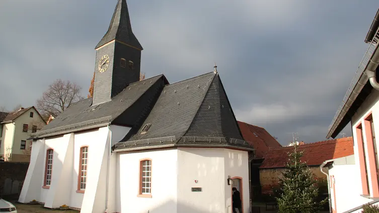 Kirche vom Gemeindehaus aus gesehen. Auf dem Hof steht der Weihnachtsbaum