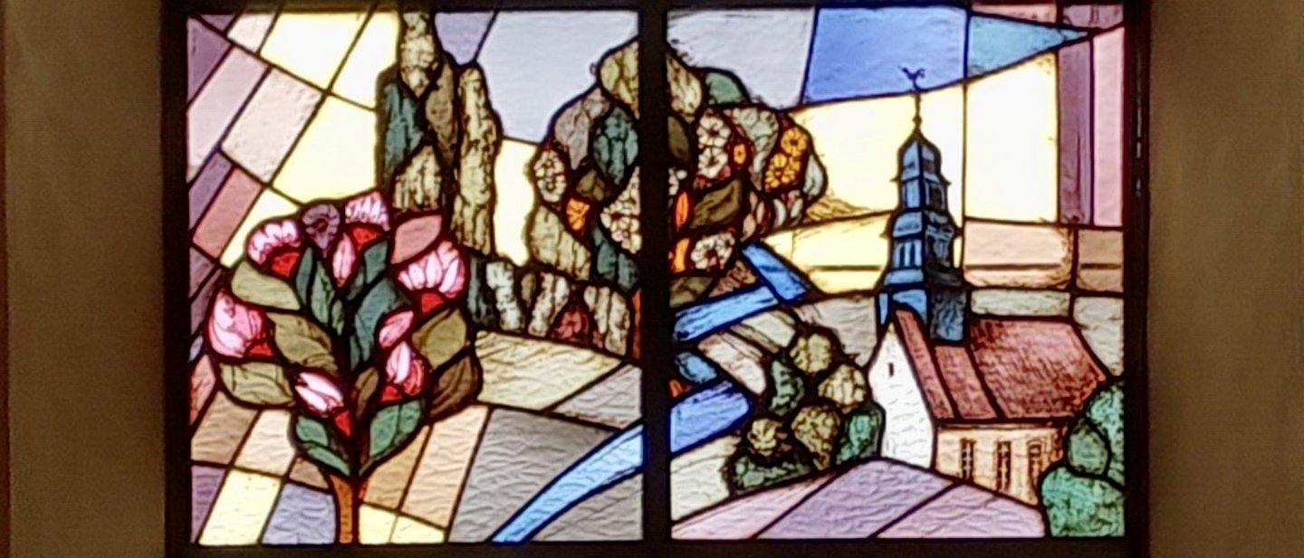Buntglasfenster von Willi Petri zeigt auf der rechten Seite die Auferstehungskirche in Praunheim.